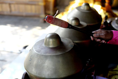 Cropped hand playing gamelan outdoors