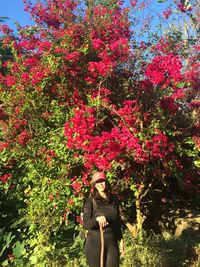 Full length of woman standing by flowers in park