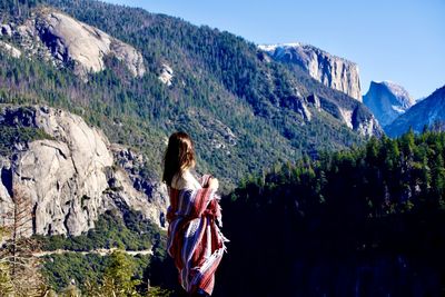 Rear view of woman standing on mountain