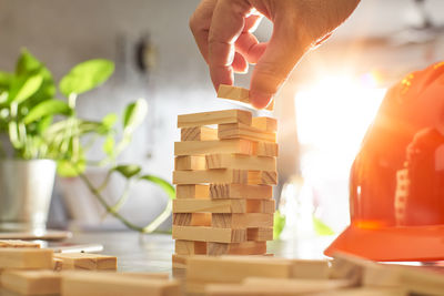 Cropped hands of women holding wooden block at table