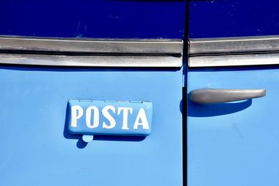 Close-up of information sign on blue door