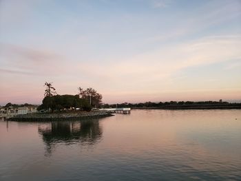 Scenic view of lake against sky at sunset