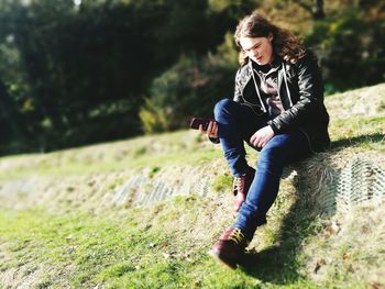 Full length of woman sitting on field