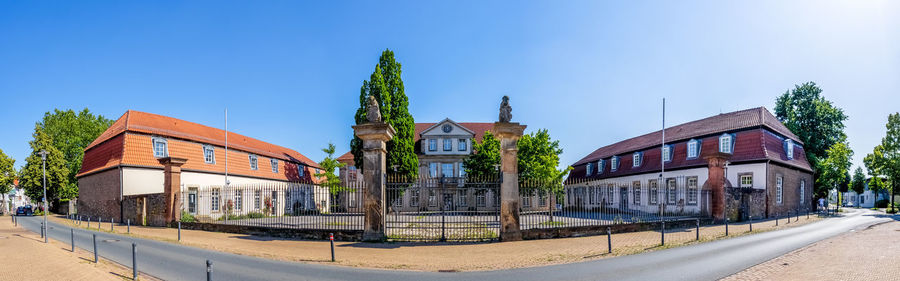 Panoramic view of buildings in city against clear blue sky