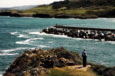 Rear view of man standing on rocks