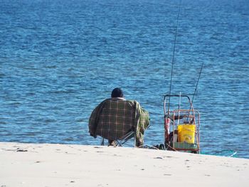 Cropped image of man on chair at beach