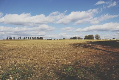 Hay bales on field against sky