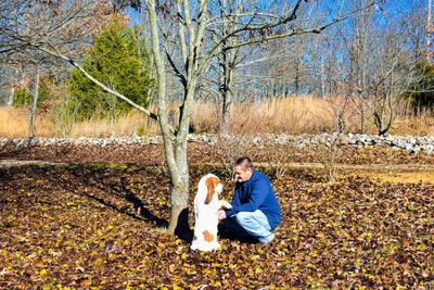 Man and dog on field during autumn