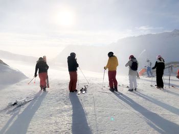 Rear view of people standing on snow covered land