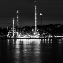 Illuminated amusement park against sky at night