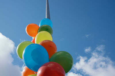 Low angle view of balloons against blue sky