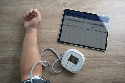 Cropped hands of woman using digital tablet on table