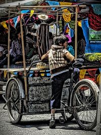 Rear view of man with bicycle on street