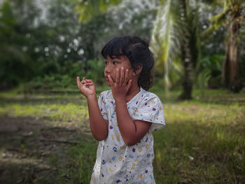 Young woman drinking water while standing outdoors