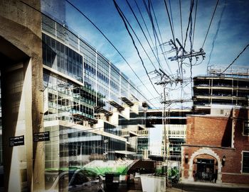 Electricity pylon with buildings in background