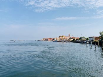 Scenic view of sea by buildings against sky