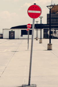 Red road sign against sky