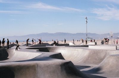 People at skateboard park against sky