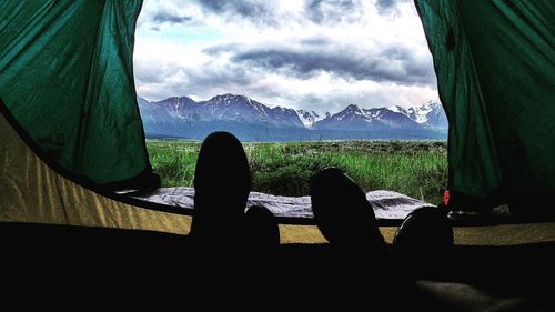 Low section of man relaxing in mountains