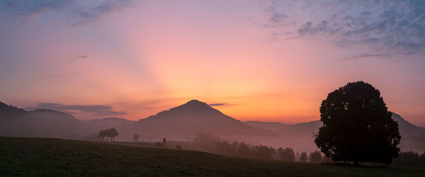 Scenic view of silhouette field against sky during sunset