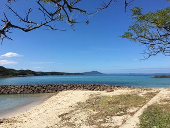 Scenic view of beach against blue sky