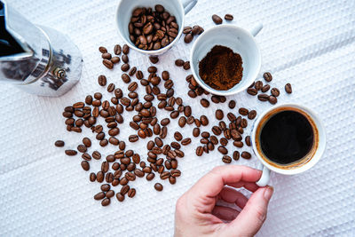 Cropped hand of woman holding coffee on table