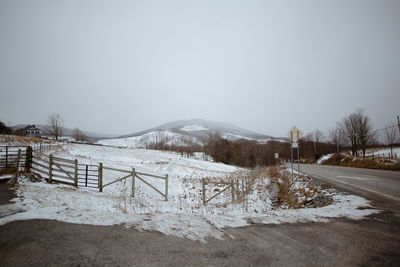 Snow covered land against clear sky