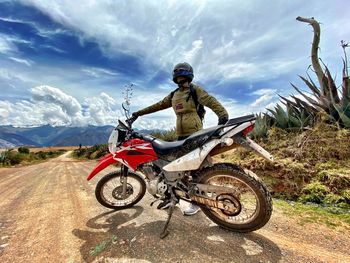 Man riding motorcycle against sky