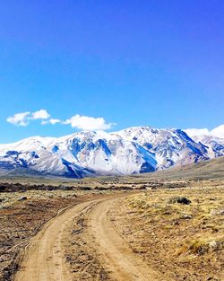 Scenic view of snowcapped mountains against blue sky