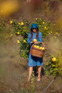 Full length of woman standing by flowering plants