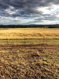 Scenic view of grassy field against cloudy sky