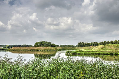 Scenic view of lake against cloudy sky