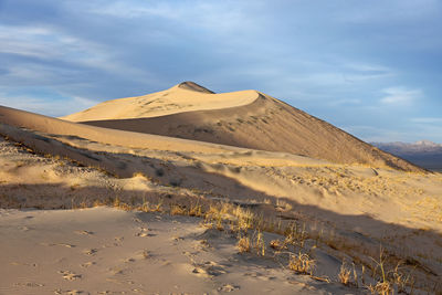 View of desert against cloudy sky