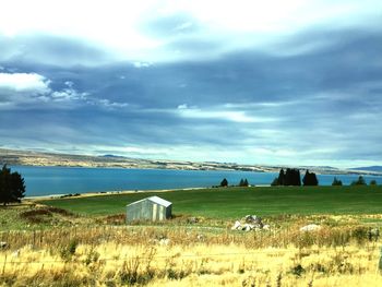 Scenic view of field against cloudy sky