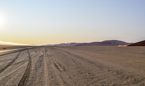 Scenic view of desert against clear sky during sunset