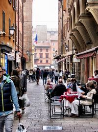 People on street amidst buildings in city