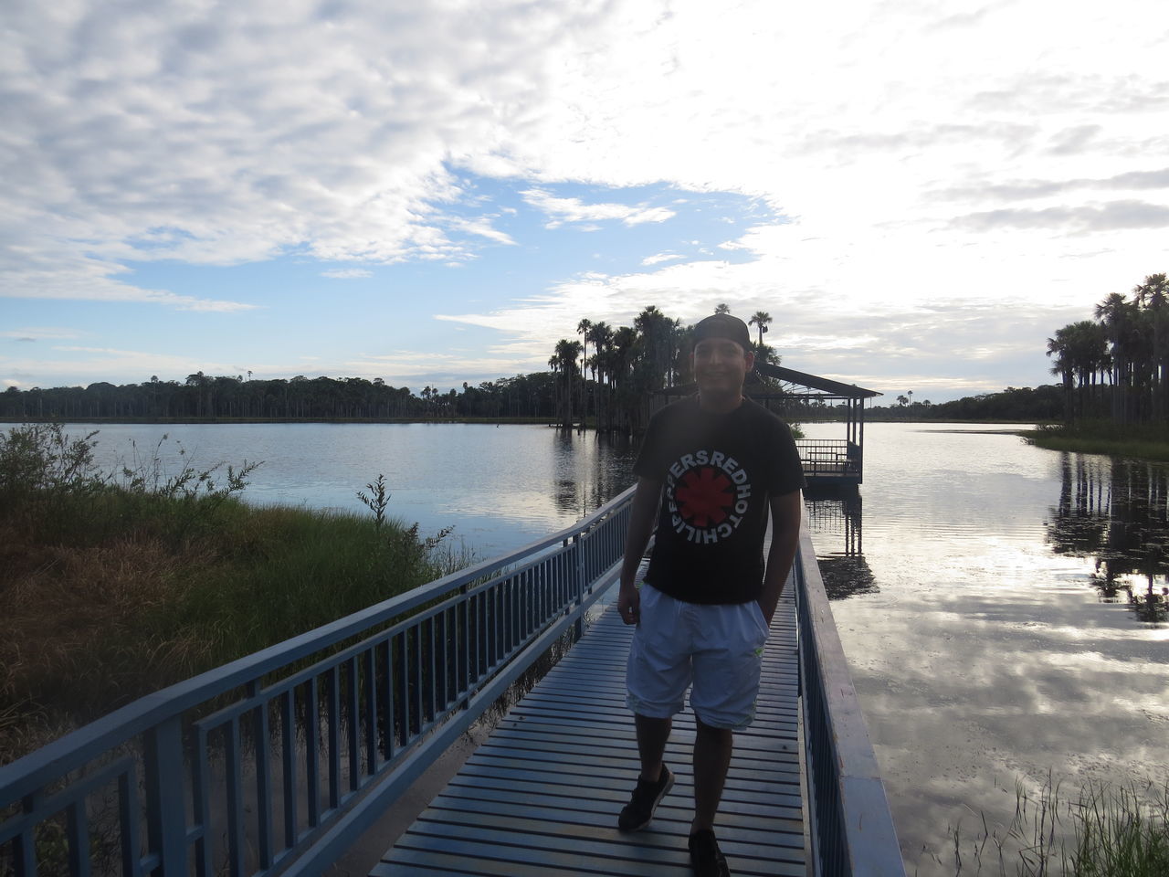 railing, real people, water, one person, sky, standing, cloud - sky, lifestyles, casual clothing, lake, leisure activity, full length, nature, adult, women, plant, architecture, day, outdoors