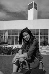 Portrait of smiling young woman sitting outdoors