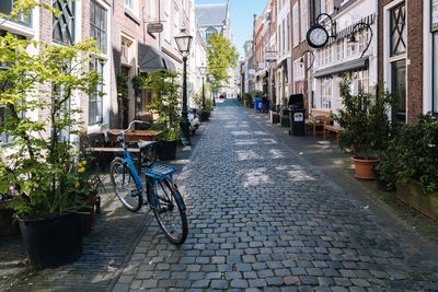 Bicycle parked on street amidst buildings in city