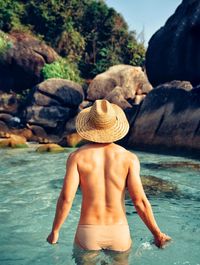 Rear view of shirtless man in sea