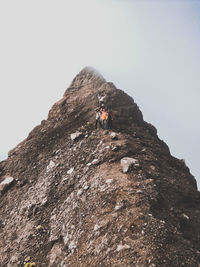 Low angle view of rocks on mountain against clear sky