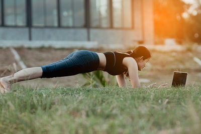 Low section of woman exercising on field