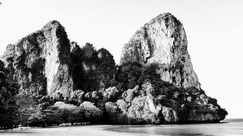 Panoramic view of cliff by sea against clear sky