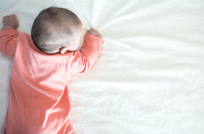 High angle view of girl lying on bed