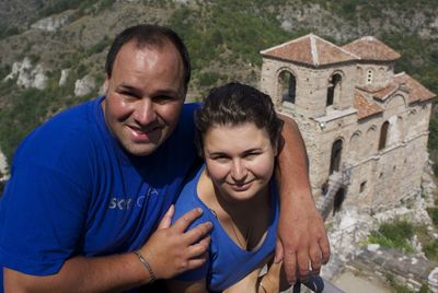 High angle portrait of couple standing against historic building