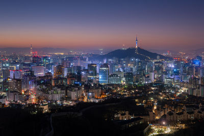 High angle view of illuminated buildings against sky at dusk