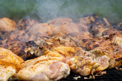 Making bbq chicken on a wood fired grill in the outdoors.