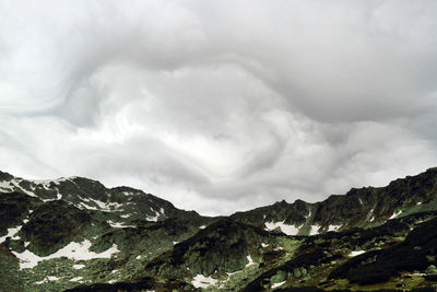 Scenic view of mountains against cloudy sky