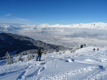 People skiing on snowcapped mountain against sky