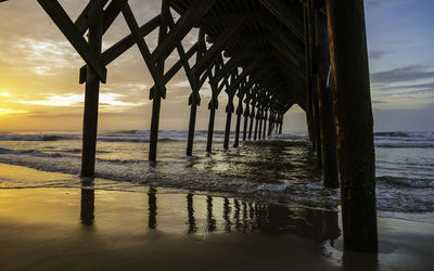 Pier over sea against sky during sunset